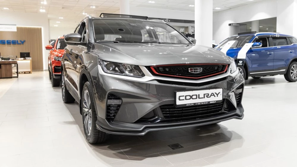 Geely Coolray дорестайлинговый у дилера в автосалоне сбоку спереди авилон