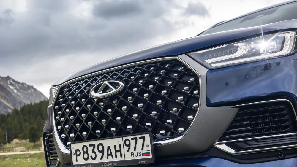 Тест гибридного Chery Tiggo 8 Pro e+ сбоку спереди решетка радиатора