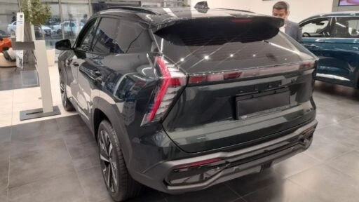 Geely Atlas нового поколения в Казахстане сзади сбоку в автосалоне