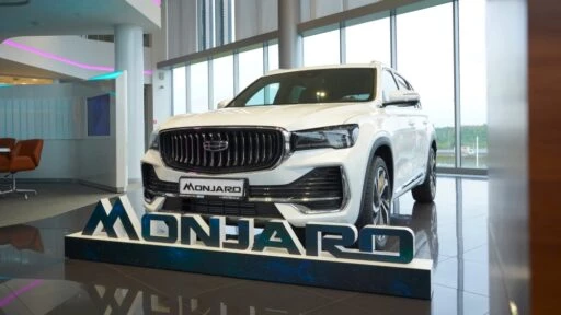 Geely Monjaro у дилера в автосалоне сбоку спереди Geely Парнас