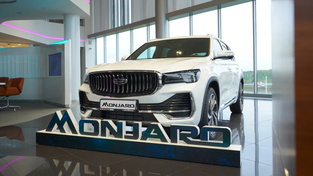 Geely Monjaro у дилера в автосалоне сбоку спереди Geely Парнас