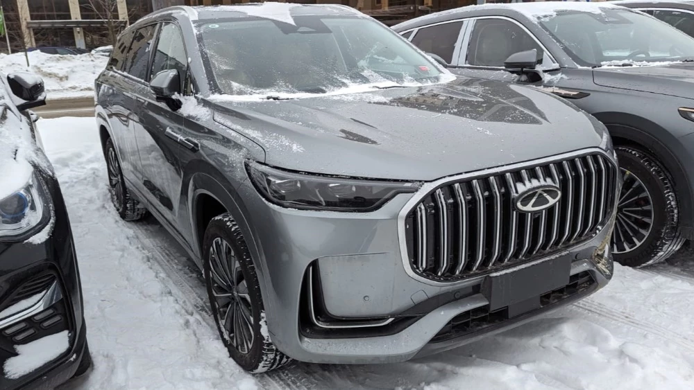 Суббренд Chery предложит в России 7 моделей в 2024 году. Что это за машины Chery Tiggo 9 сбоку спереди в России на парковке