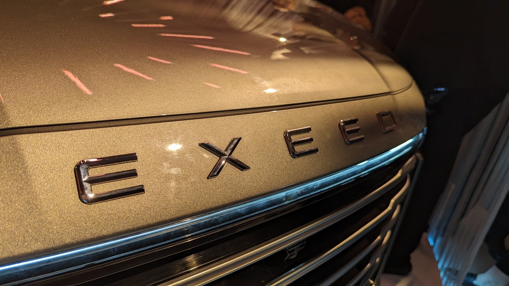 Обновленный Exeed VX нового поколения решетка радиатора логотип спереди презентация в России