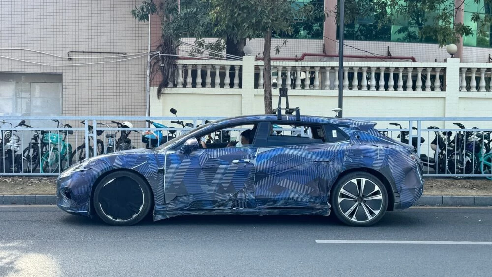 гибридный хэтчбек BYD Denza в камуфляже сбоку сзади