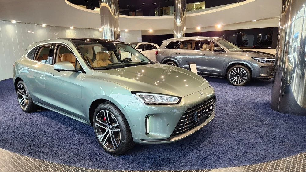 Aito M5 сбоку спереди в автосалоне в шоуруме