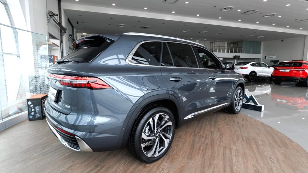 Geely Monjaro у дилера в автосалоне GEELY БИЗНЕС КАР Каширский сбоку сзади