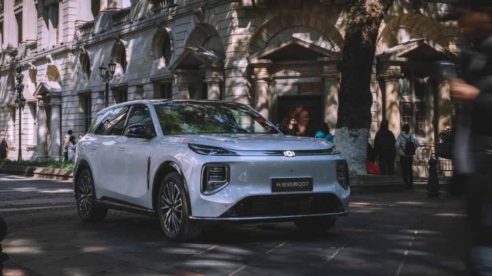 Гибридный кроссовер Changan Qiyuan Q07 спереди сбоку в динамике в городе