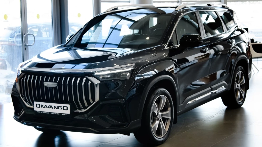 Geely Okavango у дилера бизнес кар сбоку спереди в шоуруме