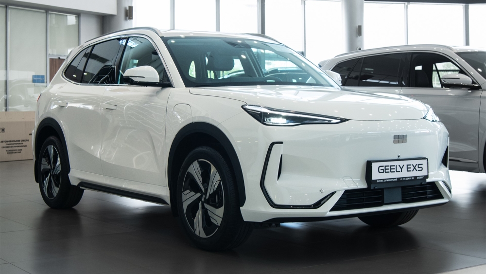 Geely EX5 у дилера бизнес кар сбоку спереди в шоуруме
