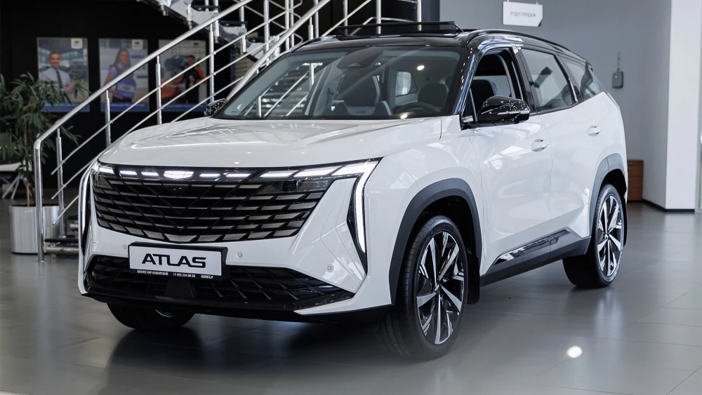 Geely Atlas у дилера бизнес кар сбоку спереди в шоуруме