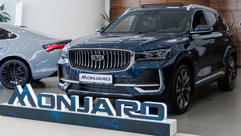 Geely Monjaro у дилера бизнес кар сбоку спереди в шоуруме