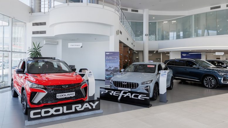 Geely у дилера бизнес кар сбоку спереди в шоуруме