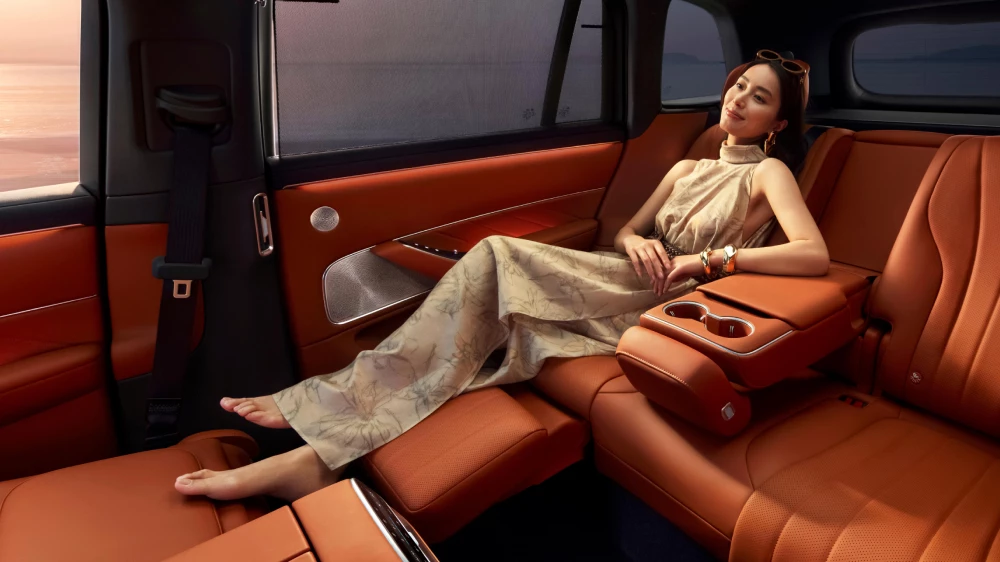 Электрический кроссовер Aito M8 салон интерьер второй ряд сиденья женщина пассажир