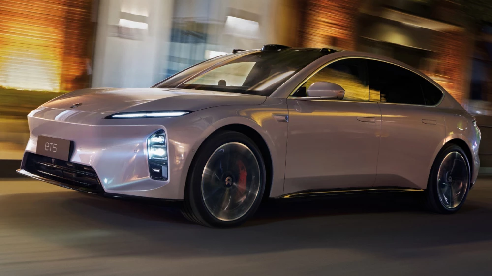 седан nio et5 сбоку спереди электрчиеский в движении полноприводный электромобиль