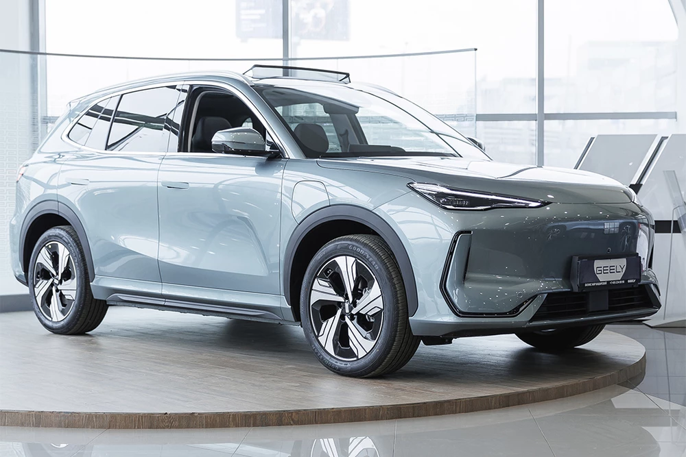geely ex5 у дилера в автосалоне бизнес кар сбоку спереди