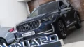 geely monjaro у дилера в автосалоне бизнес кар сбоку спереди