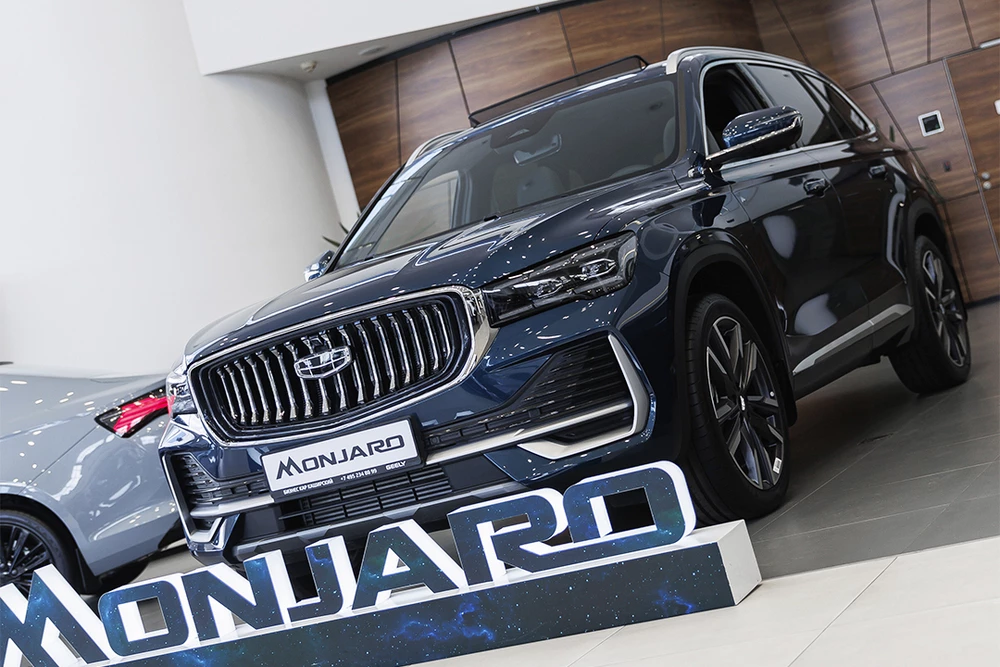 geely monjaro у дилера в автосалоне бизнес кар сбоку спереди