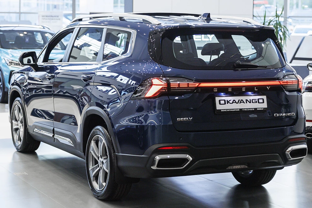 geely okavango у дилера в автосалоне бизнес кар сбоку спереди