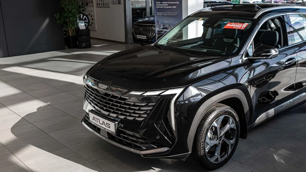 Geely Atlas у дилера в автосалоне новый купить сбоку спереди автодин