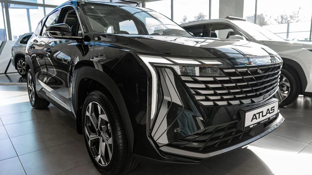 Geely Atlas у дилера в автосалоне новый купить сбоку спереди автодин