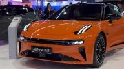обновленный zeekr 001 в узбекистане автосалон в ташкенте tashkent auto show оранжевый сбоку спереди рестайлинг