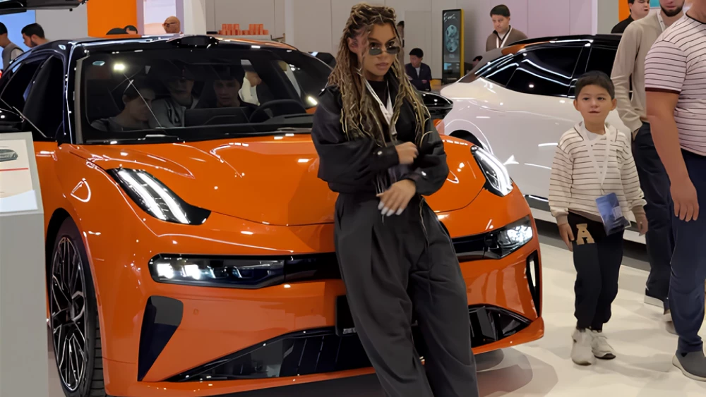 обновленный zeekr 001 в узбекистане автосалон в ташкенте tashkent auto show оранжевый сбоку спереди рестайлинг