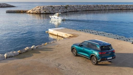Гибридный кроссовер BYD Atto 2 DM-i в Европе сбоку сзади море берег