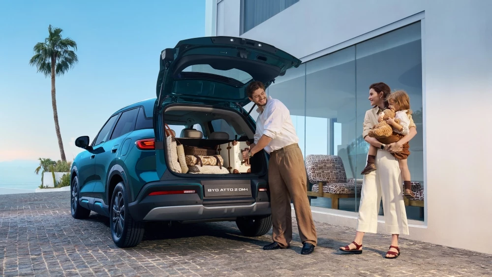 Гибридный кроссовер BYD Atto 2 DM-i в Европе сбоку сзади мужчина багажник вещи
