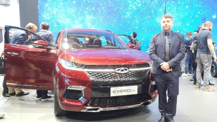 Шеф-дизайнер Chery Джеймс Хоуп рядом с кроссовером Chery Exeed TX