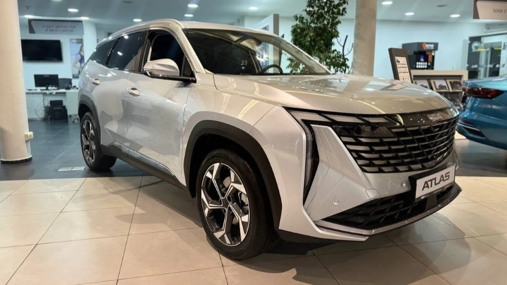 Geely Atlas 1.5 полуторалитровый сбоку спереди у дилера в автосалоне новый