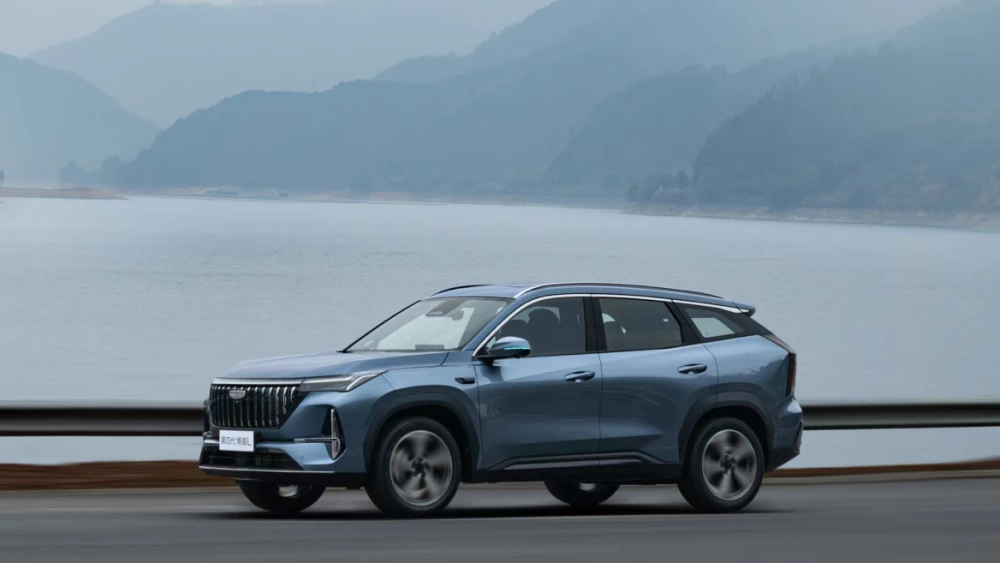 Geely Atlas научится ездить без водителя кроссовер сбоку спереди голубой