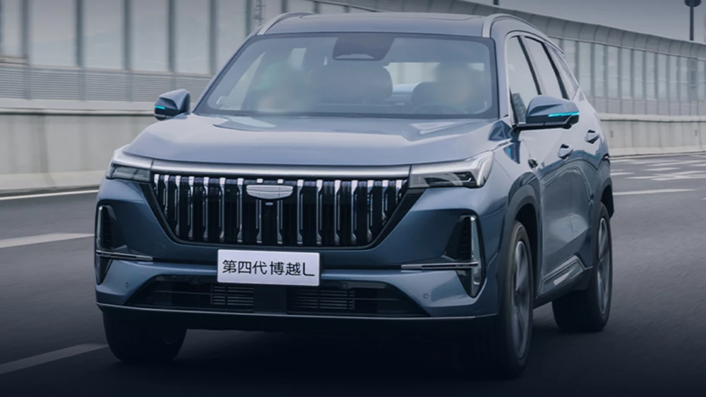 Geely Atlas научится ездить без водителя кроссовер сбоку спереди голубой