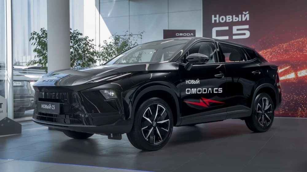 Omoda C5 новый обновленный сбоку спереди у дилера в автосалоне авилон