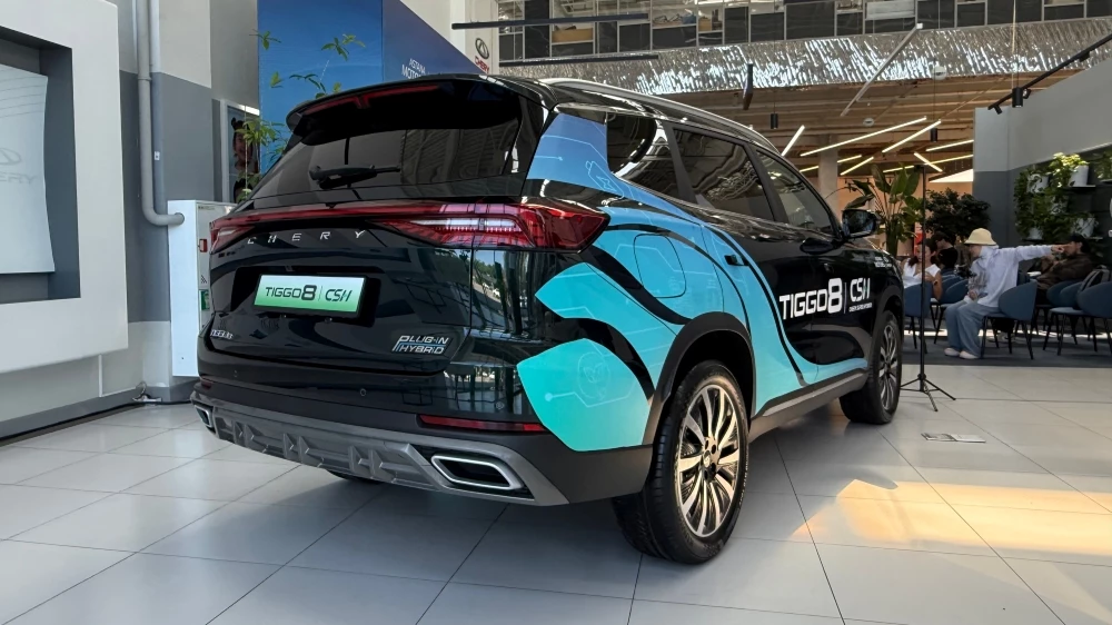 Кроссовер Chery Tiggo 8 PHEV у дилера в автосалоне в Казахстане сбоку сзади