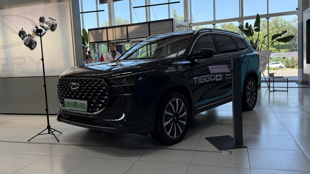 Кроссовер Chery Tiggo 8 PHEV у дилера в автосалоне в Казахстане сбоку спереди