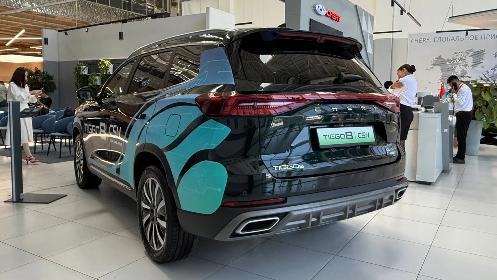 Кроссовер Chery Tiggo 8 PHEV у дилера в автосалоне в Казахстане сбоку сзади