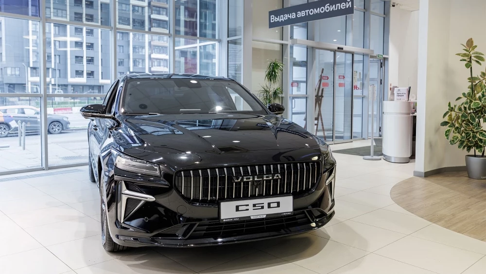 Автомобили Volga C50 у дилера в автосалоне шоурум Бизнес Кар сбоку спереди