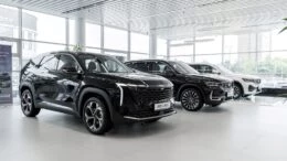 дилерский центр GEELY БалтАвтоТрейд-М сбоку спереди автомобили у дилера в автосалоне