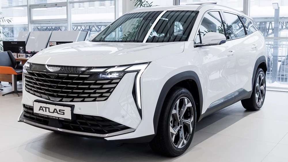 Geely Atlas у дилера в автосалоне белый сбоку спереди дилерский центр GEELY БалтАвтоТрейд-М