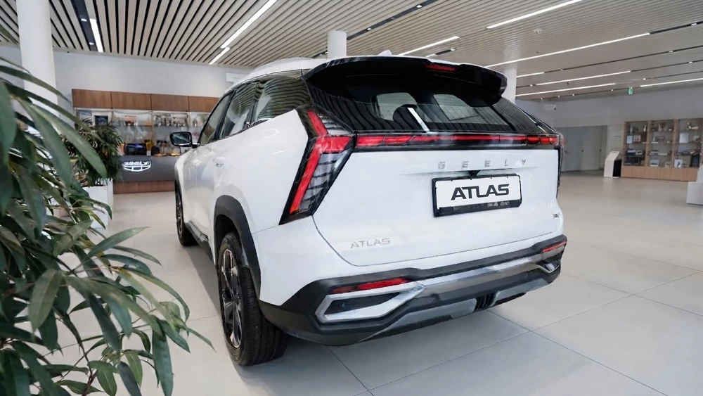Geely Atlas у дилера в автосалоне белый сбоку сзади дилерский центр GEELY БалтАвтоТрейд-М