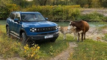 Jetour T1 тест-драйв в Казахстане на бездорожье сбоку спереди синий коровы