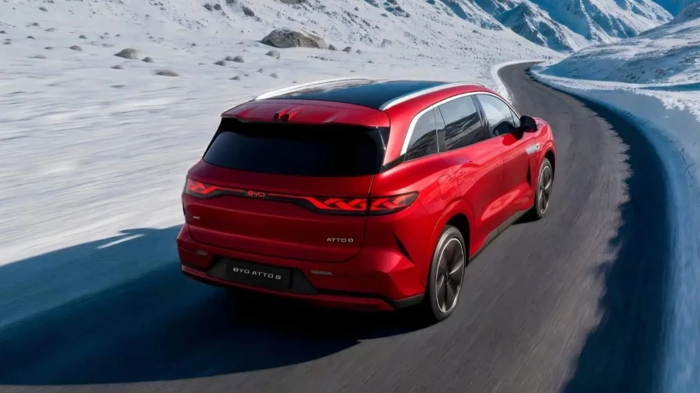 Кроссовер BYD Atto 8 сбоку сзади зимой на снегу в динамике