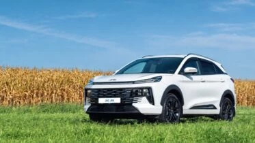 Обновленный кроссовер JAC JS6 сбоку спереди кукурузное поле белый